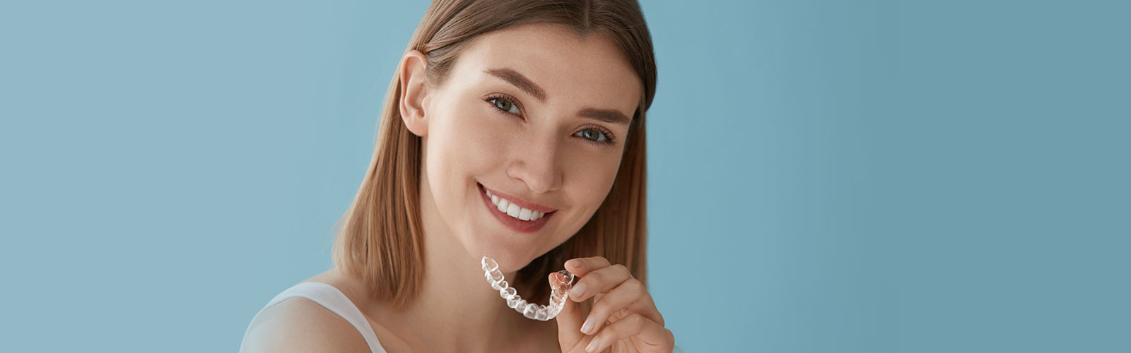 Woman holding invisalign clear aligner